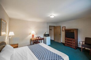 A hotel room with a bed, desk, chair, television, and a dresser. - Econo Lodge Hornell (Hornell)