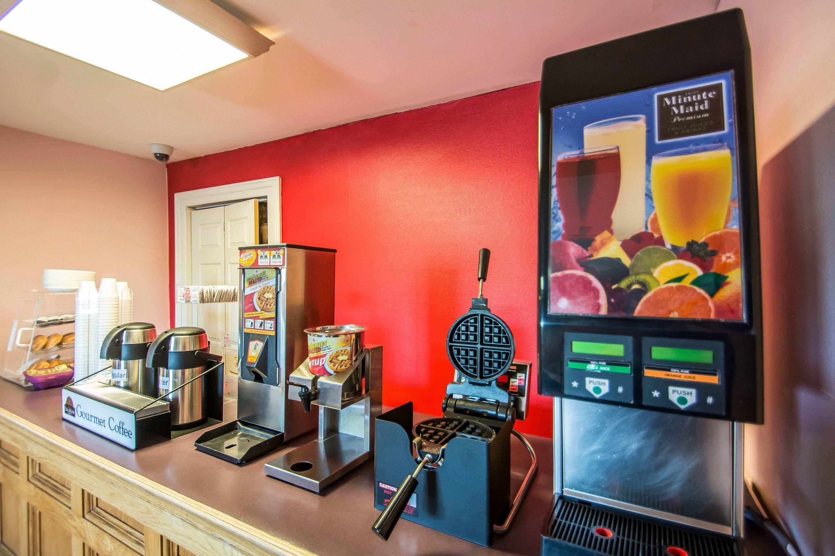 A coffee station with various coffee machines and a juice dispenser.