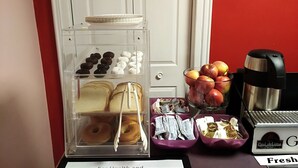 A breakfast display with pastries, donuts, and fresh fruits. - Econo Lodge Hornell (Hornell)