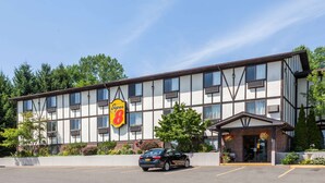 A hotel with a sign reading "Super 8" and a parking lot with a car.