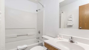 A modern bathroom with a bathtub, toilet, and sink.