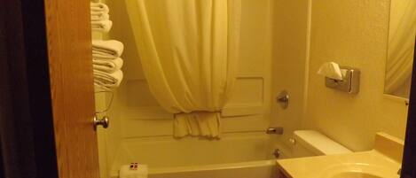 Un baño con bañera, inodoro y lavamanos.