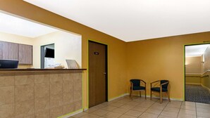 Un espace d’accueil comprenant un comptoir de réception, une porte portant l’inscription « Bureau » et deux chaises.