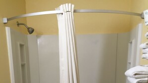 Une salle de bain avec douche, toilettes et lavabo.