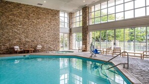 Ein Hallenbad mit Steinwänden und großen Fenstern.