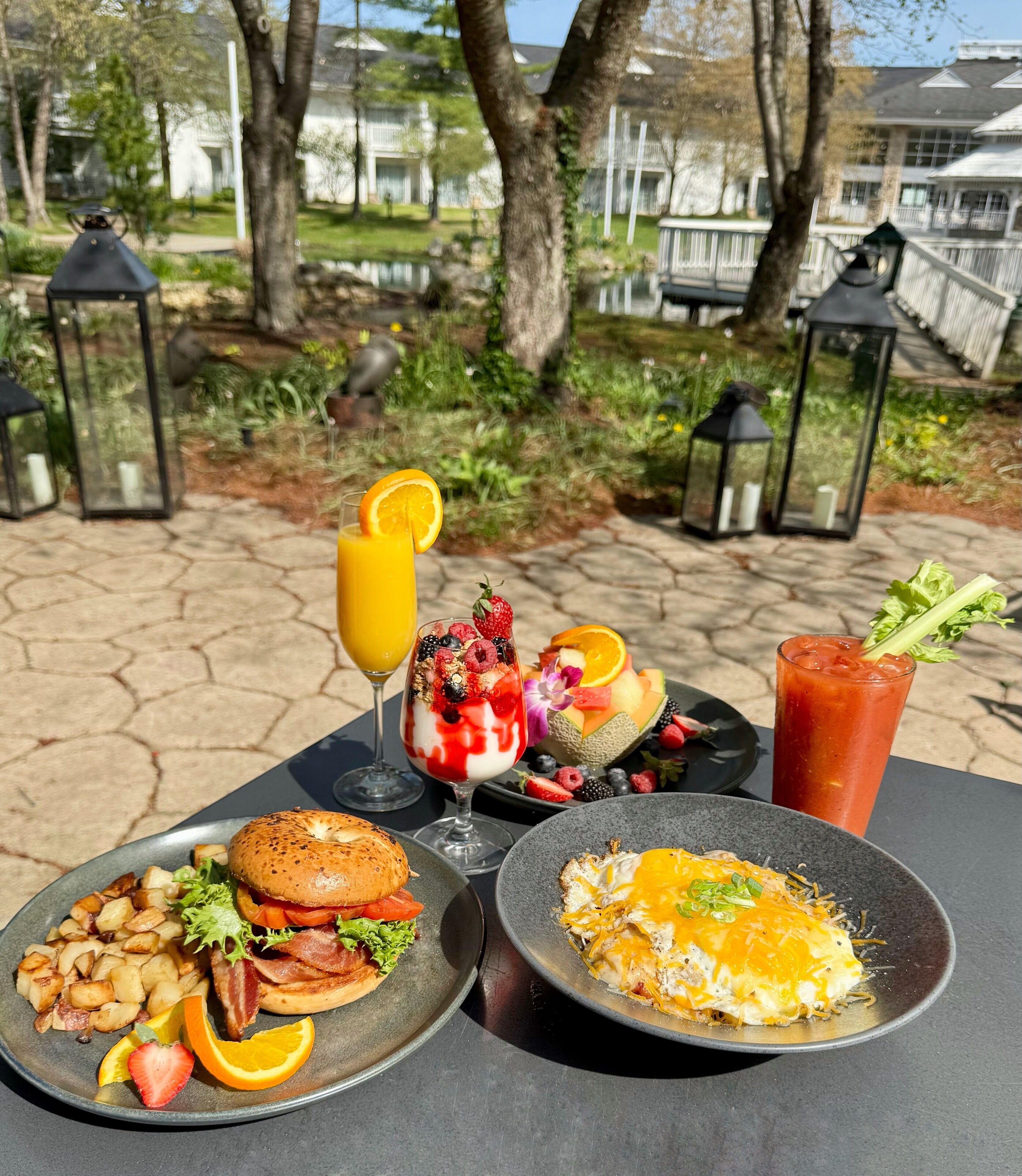 A table with breakfast items including a burger, eggs, and fruit.