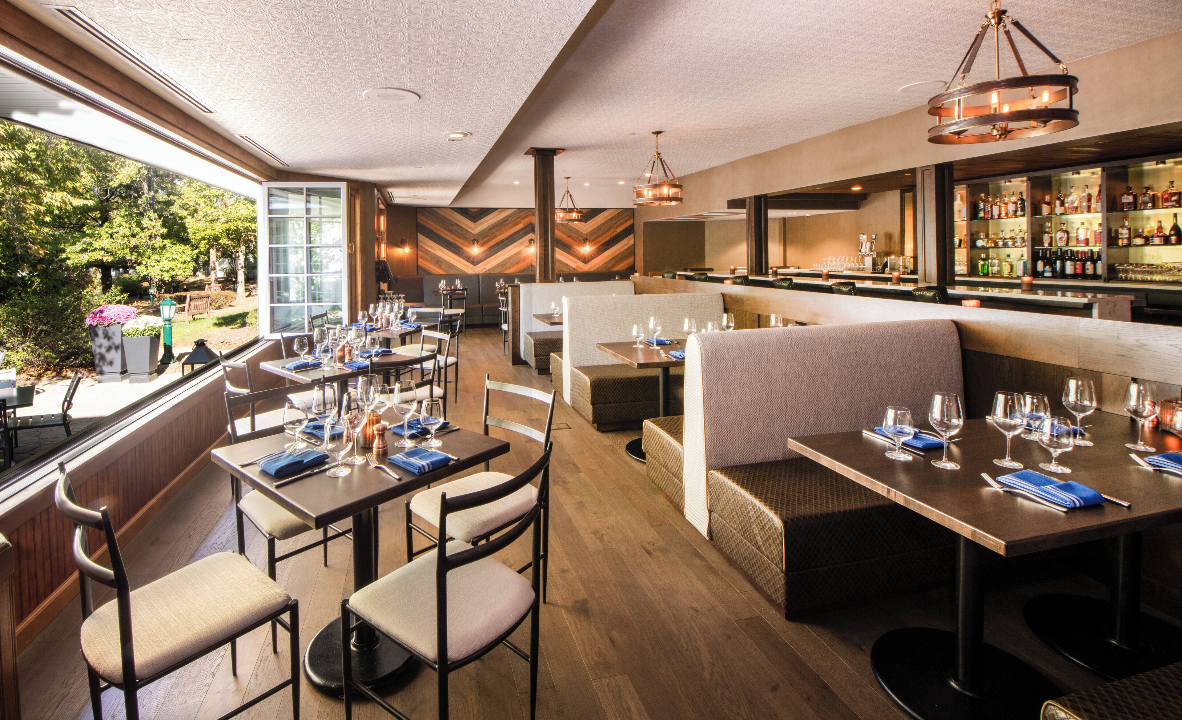 Un restaurant doté de plusieurs espaces de restauration, notamment des banquettes et des tables, ainsi qu’un bar proposant un large choix de boissons.