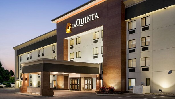 Een modern hotel met een opvallende ingang, meerdere verdiepingen en een goed verlichte gevel.
