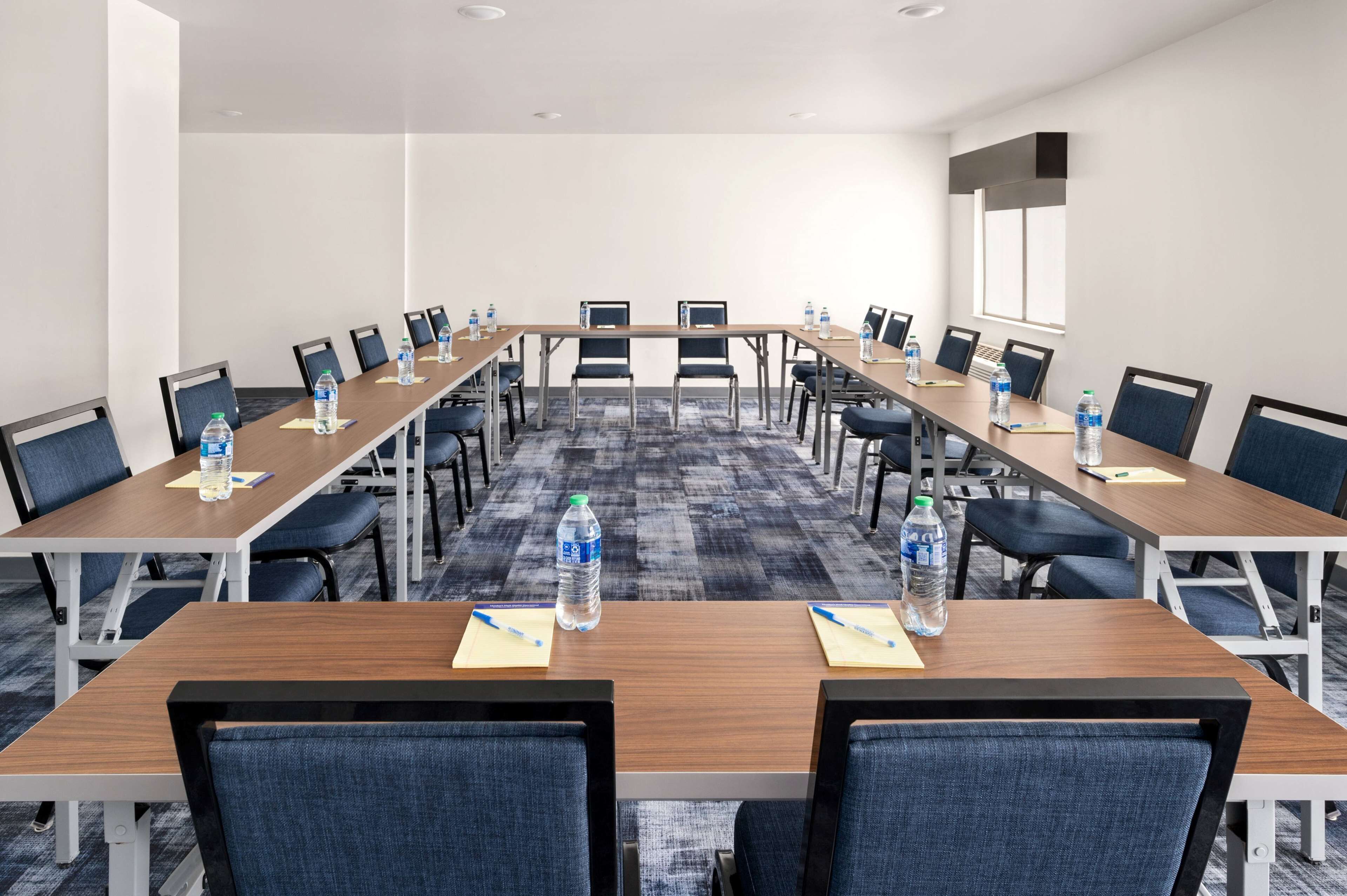 A conference room with long tables, chairs, and water bottles.