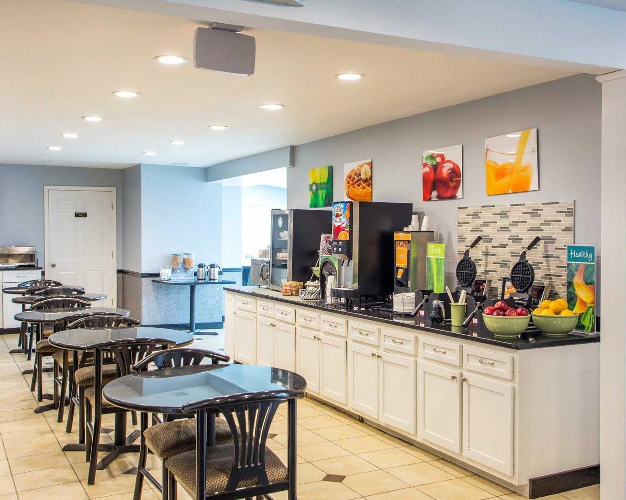 A modern kitchen with a central island, seating area, and various appliances.