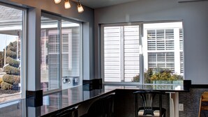 A modern kitchen with skylights, large windows, and a dining area with chairs. - Quality Inn & Suites North/Polaris (Columbus)
