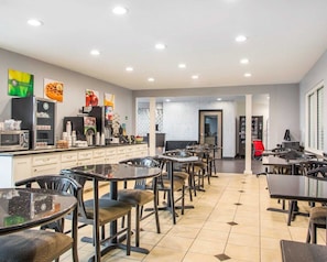 A modern restaurant with a long counter, multiple seating areas, and a variety of food and drink options. - Quality Inn & Suites North/Polaris (Columbus)