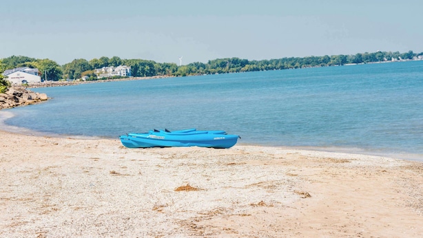 A beach with a blue kayak and a clear view of the shoreline. - Super 8 by Wyndham Port Clinton (Port Clinton)
