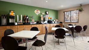 A breakfast area with a coffee machine, a refrigerator, and a clock on the wall. - Super 8 by Wyndham Richmond/Chamberlayne Rd (Richmond)