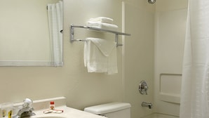 A bathroom with a sink, toilet, and shower. There are towels on a rack and a shower curtain. - Super 8 by Wyndham Richmond/Chamberlayne Rd (Richmond)