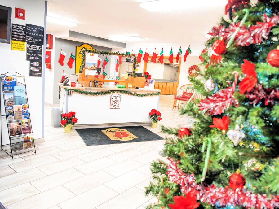 Una zona de recepción con mostrador, un árbol de Navidad y decoración navideña.
