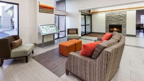 A spacious lobby with a fireplace, comfortable seating, and a digital information kiosk. - Wingate by Wyndham Canton/Hall of Fame (Canton)