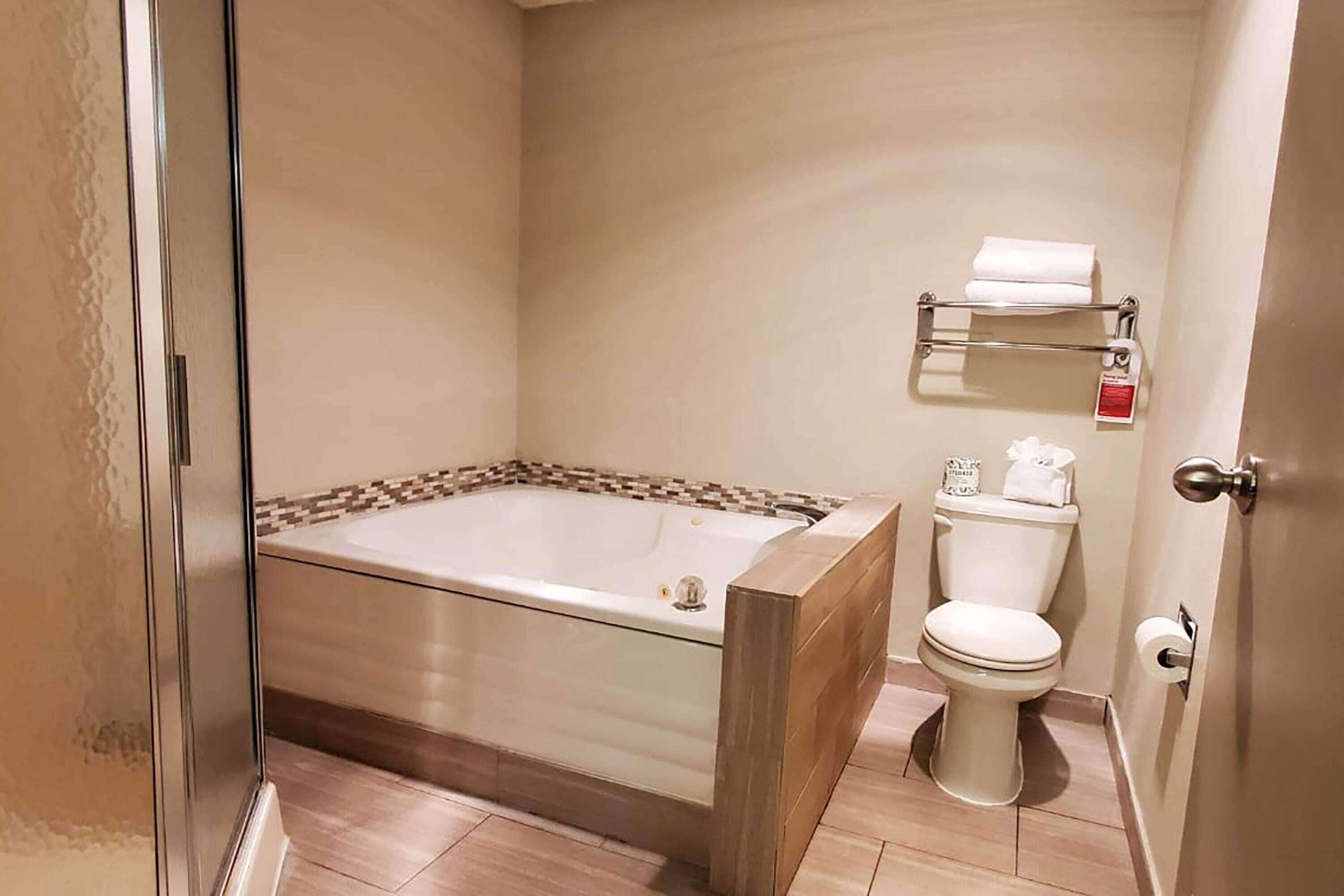 Un baño con ducha acristalada, bañera y retrete.
