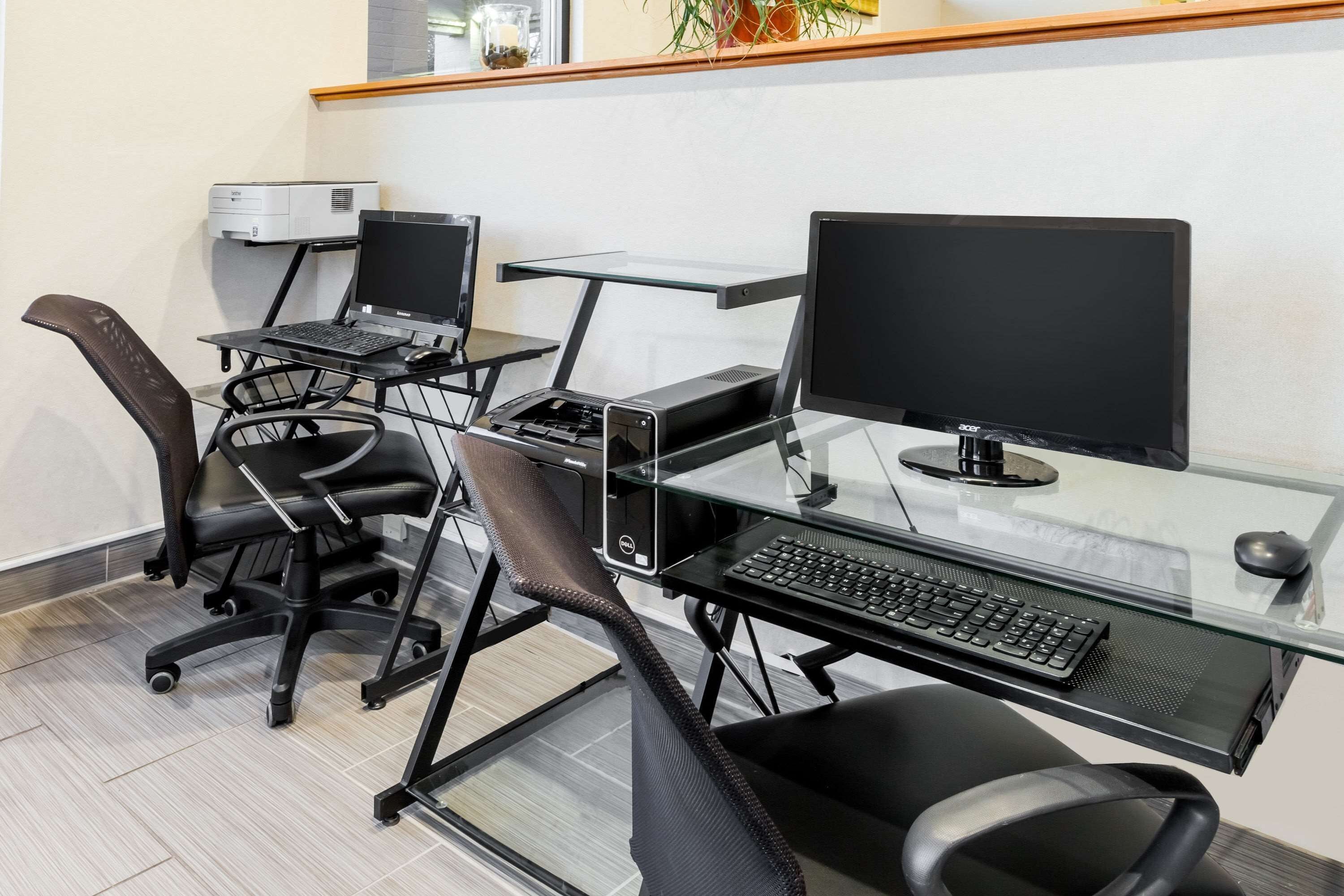 A modern office space with multiple workstations, each equipped with a desktop computer, keyboard, and mouse.