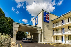 A motel with a prominent 'Motel 6' sign, a covered parking area, and a two-story building with balconies.