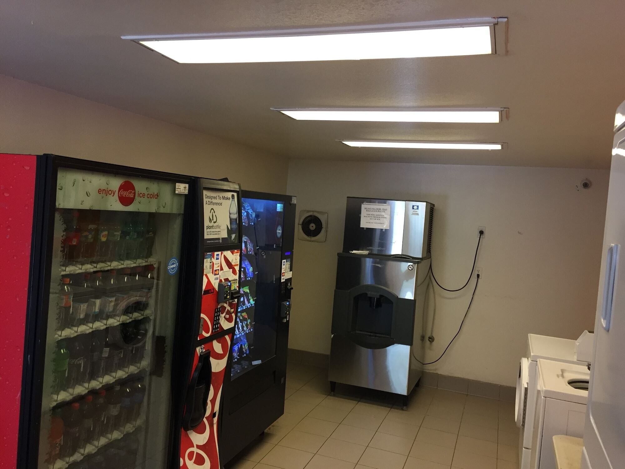 A room with vending machines, a water dispenser, and a refrigerator.