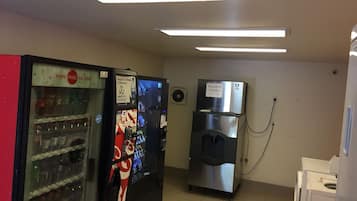 A room with vending machines, a water dispenser, and a refrigerator.