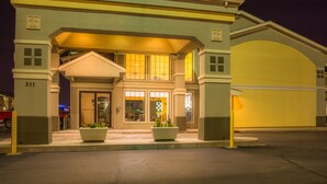 A hotel entrance with a covered driveway, large windows, and a garage.