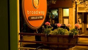 An outdoor seating area with a sign for 'Broadway Grille & Pub'.