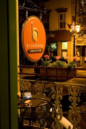 An outdoor seating area with a sign for 'Broadway Grille & Pub'.