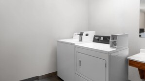 Une buanderie équipée d’un lave-linge, d’un sèche-linge et d’un petit évier.