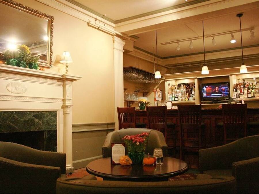 A hotel lobby with a fireplace, a bar area, and seating arrangements.