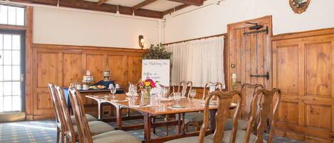 A dining room with a wooden table and chairs, a ceiling fan, and a sign reading "The Middlebury Inn."