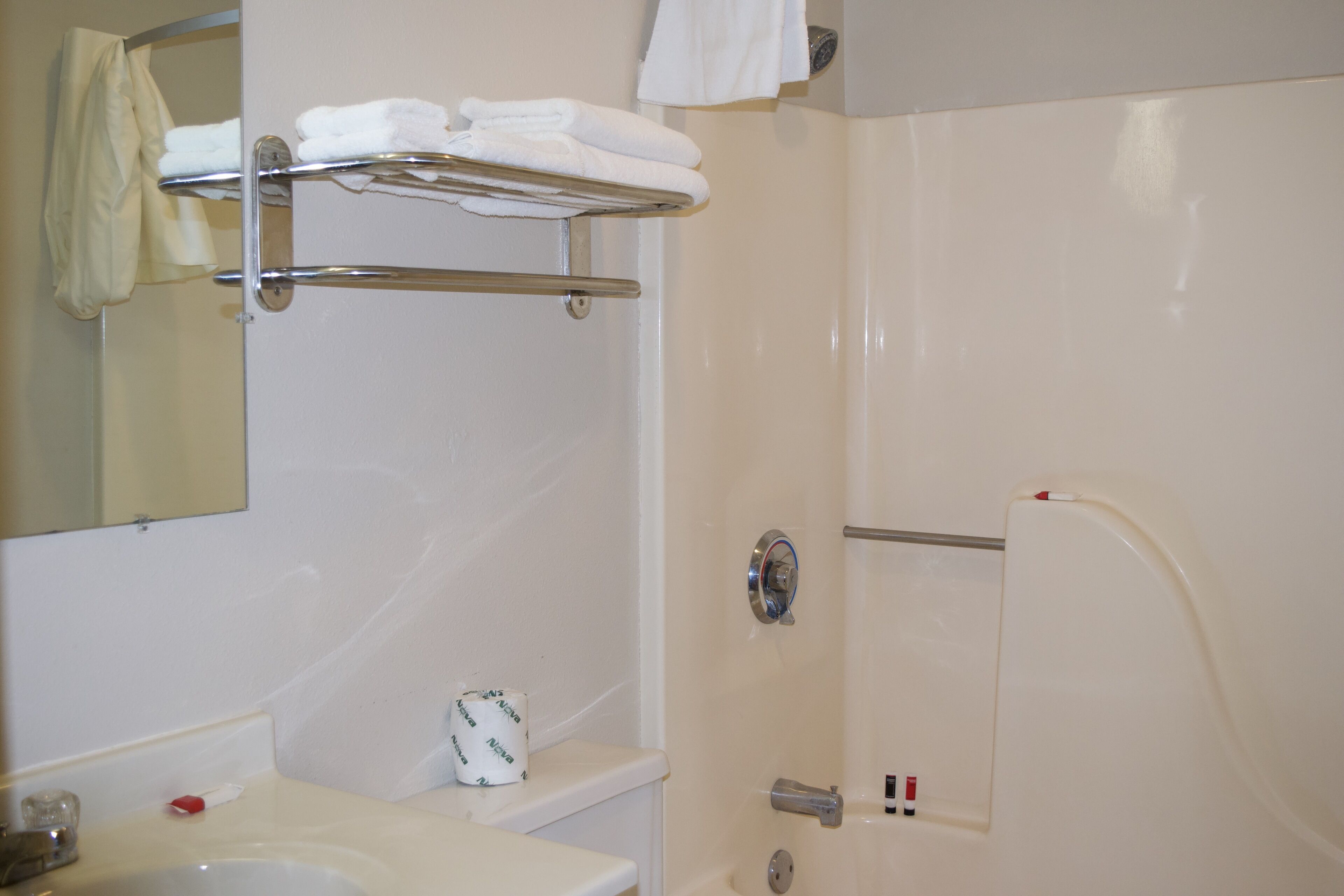 Une salle de bain équipée d’un lavabo, d’un miroir, d’un porte-serviettes, de toilettes et d’une douche.