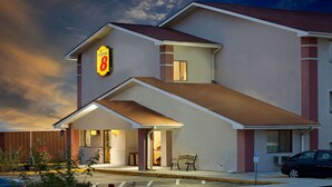 Un hotel con un llamativo letrero de 'Super 8', un acceso cubierto y un estacionamiento.