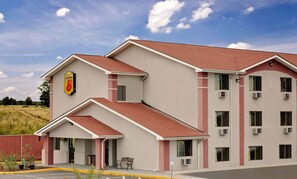 A hotel with a prominent 'Super 8' sign, a red and white exterior, and multiple air conditioning units. - Super 8 by Wyndham Waynesboro (Waynesboro)