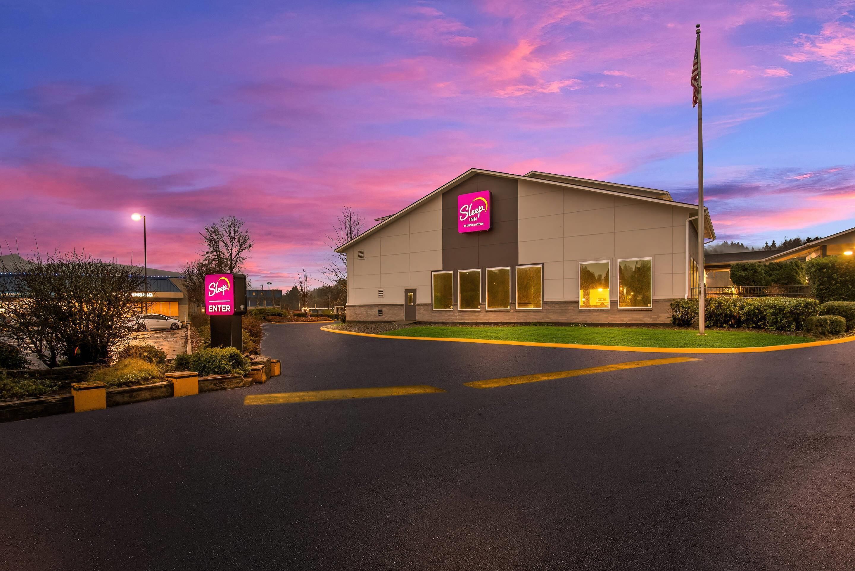 Un bâtiment de la chaîne Sleep Inn, qui fait partie du groupe Choice Hotels, avec un ciel dégagé et un coucher de soleil.