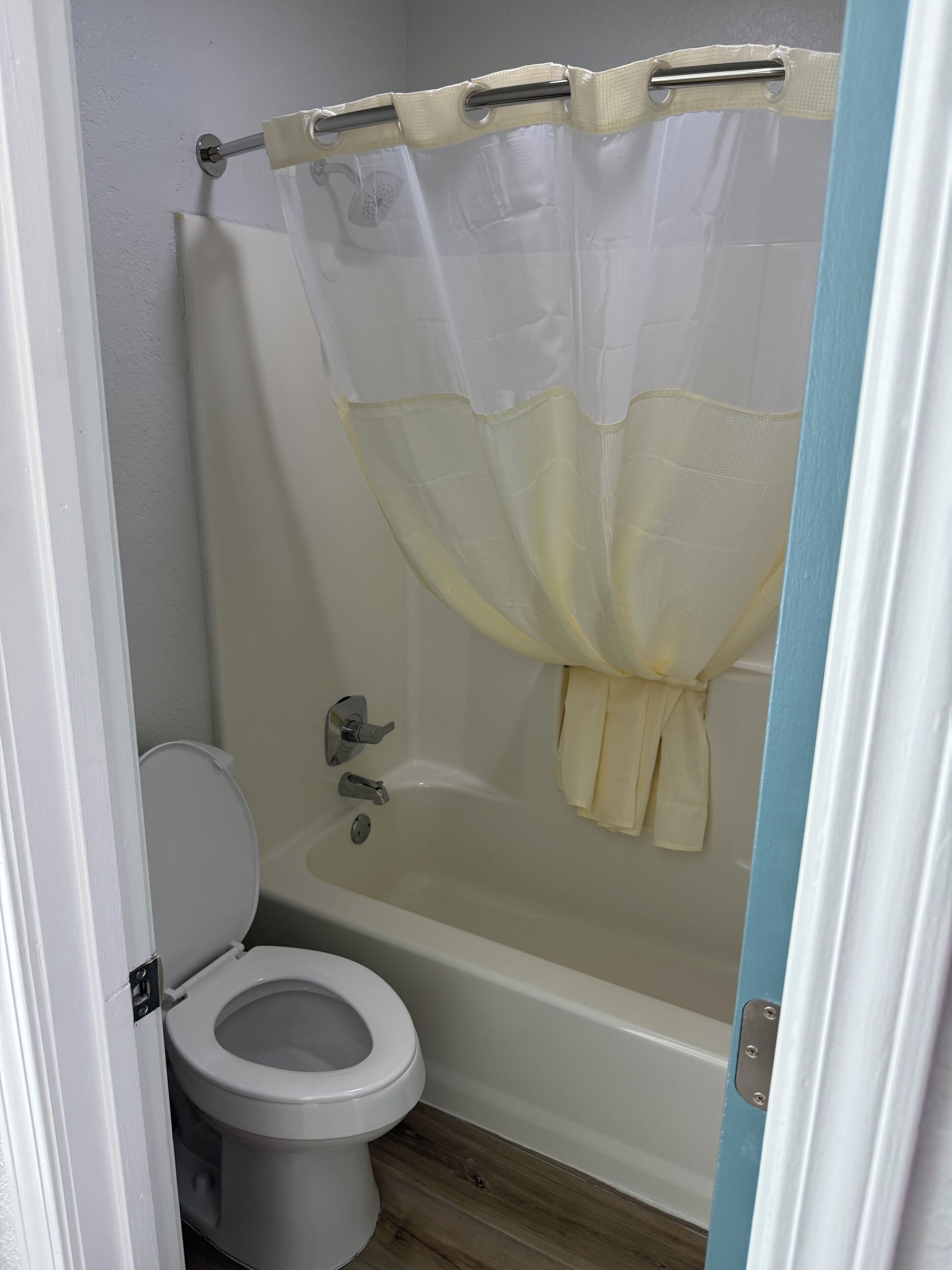 Une salle de bain équipée de toilettes, d’une baignoire et d’un rideau de douche.