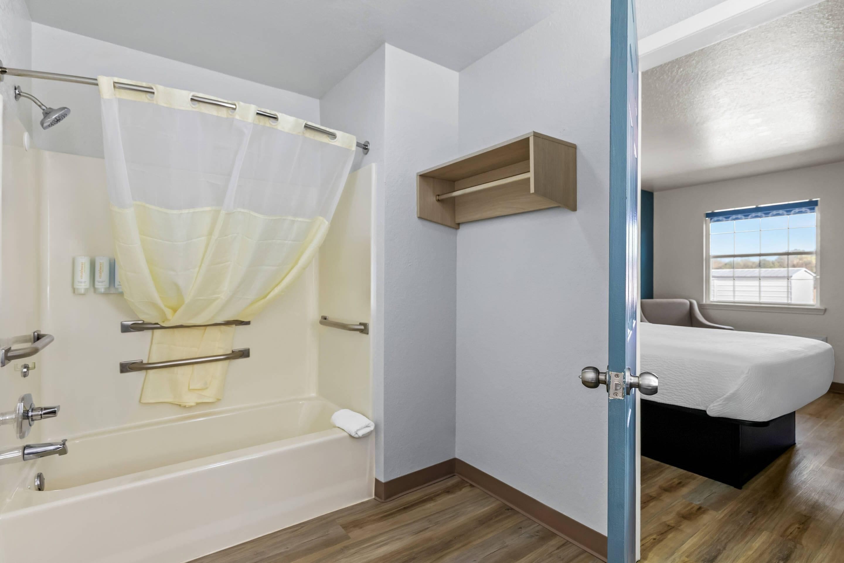 A bathroom with a bathtub, shower, and a window with a view.