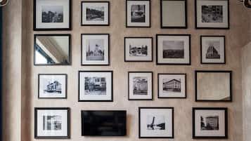 Eine Wand mit mehreren gerahmten Schwarz-Weiß-Fotografien von verschiedenen Gebäuden und Sehenswürdigkeiten.