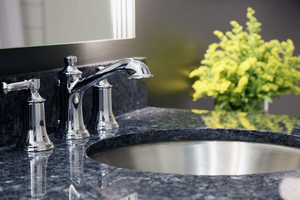 A bathroom sink with a modern faucet and a mirror above it.
