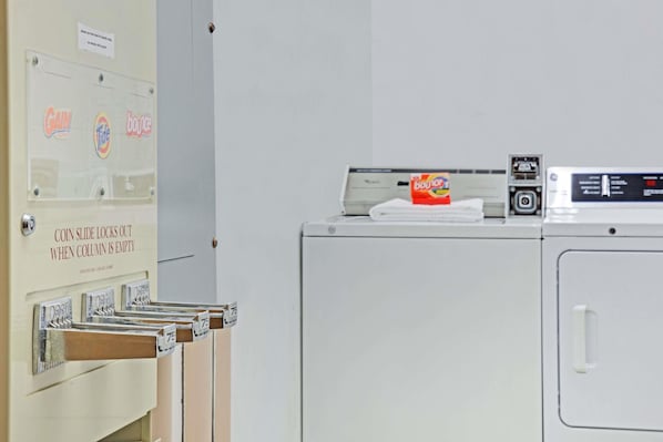 A laundry area with a coin-operated dryer and a row of coin slots.