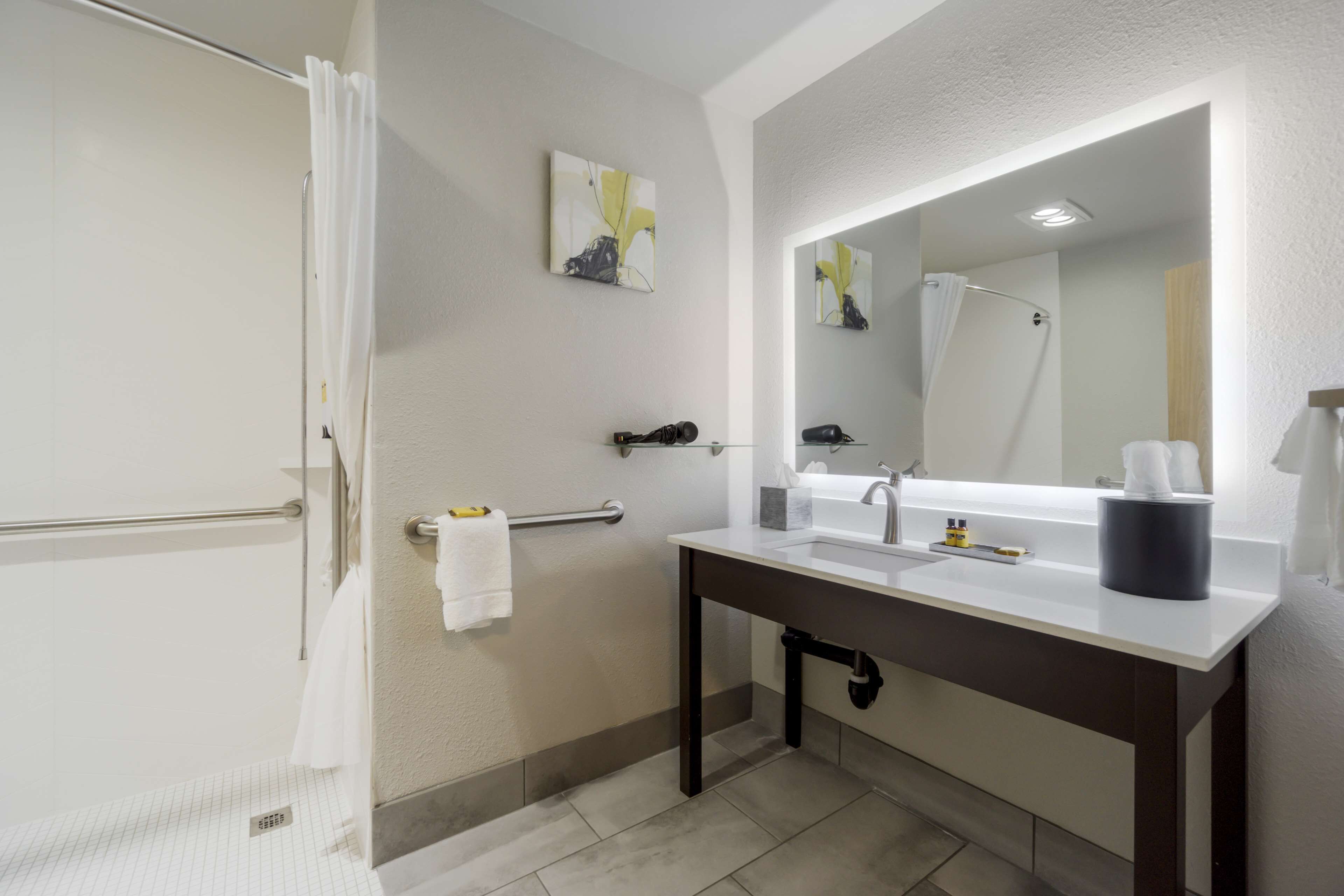A modern bathroom with a shower, a sink with a mirror, and a towel rack.