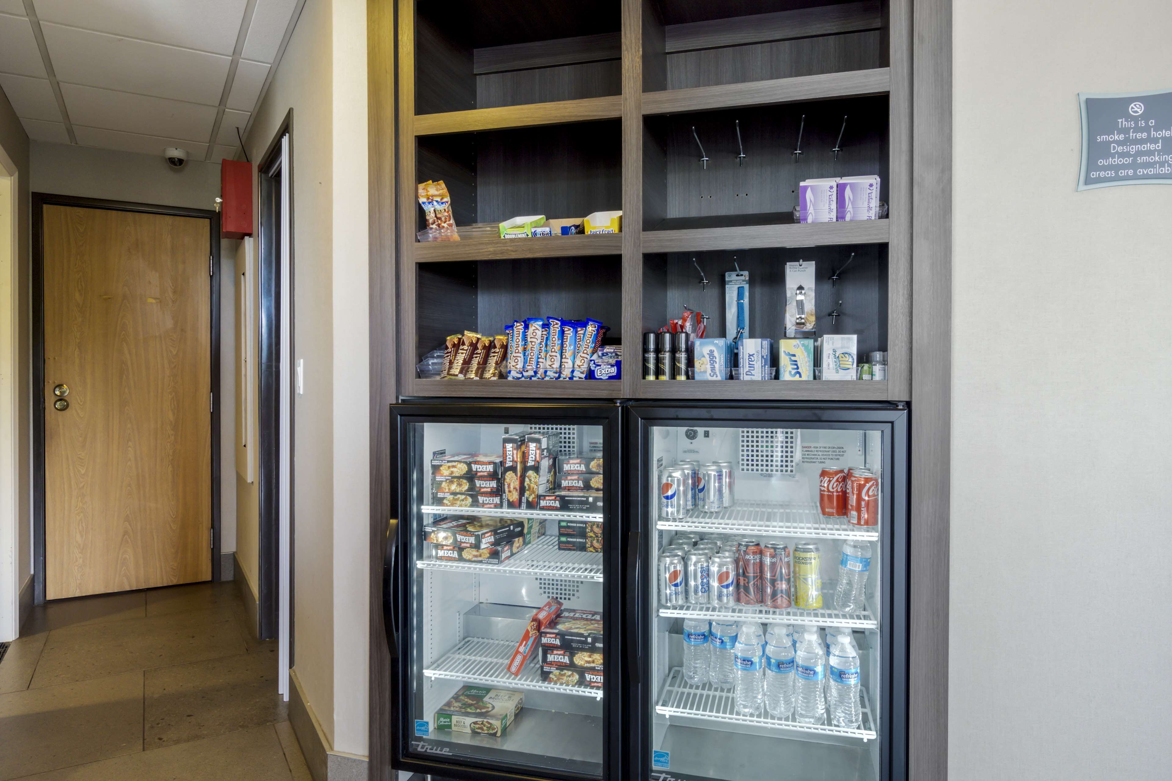 A hallway with a vending machine stocked with snacks and beverages.