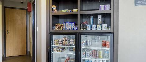A hallway with a vending machine stocked with snacks and beverages.