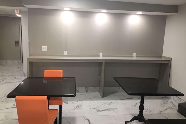 A conference room with two tables, chairs, and a marble floor. - Microtel Inn by Wyndham Charlotte Airport (Charlotte)
