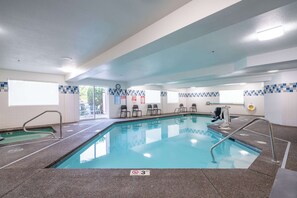 Una piscina interior con agua cristalina, paredes con azulejos y un indicador de profundidad de 3 pies.