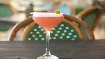 Un cóctel en una copa de martini sobre una mesa de madera.