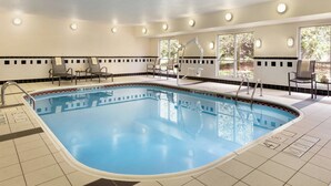 A swimming pool with chairs and sun loungers around it, surrounded by windows. - Fairfield Inn & Suites Toledo Maumee (Maumee)