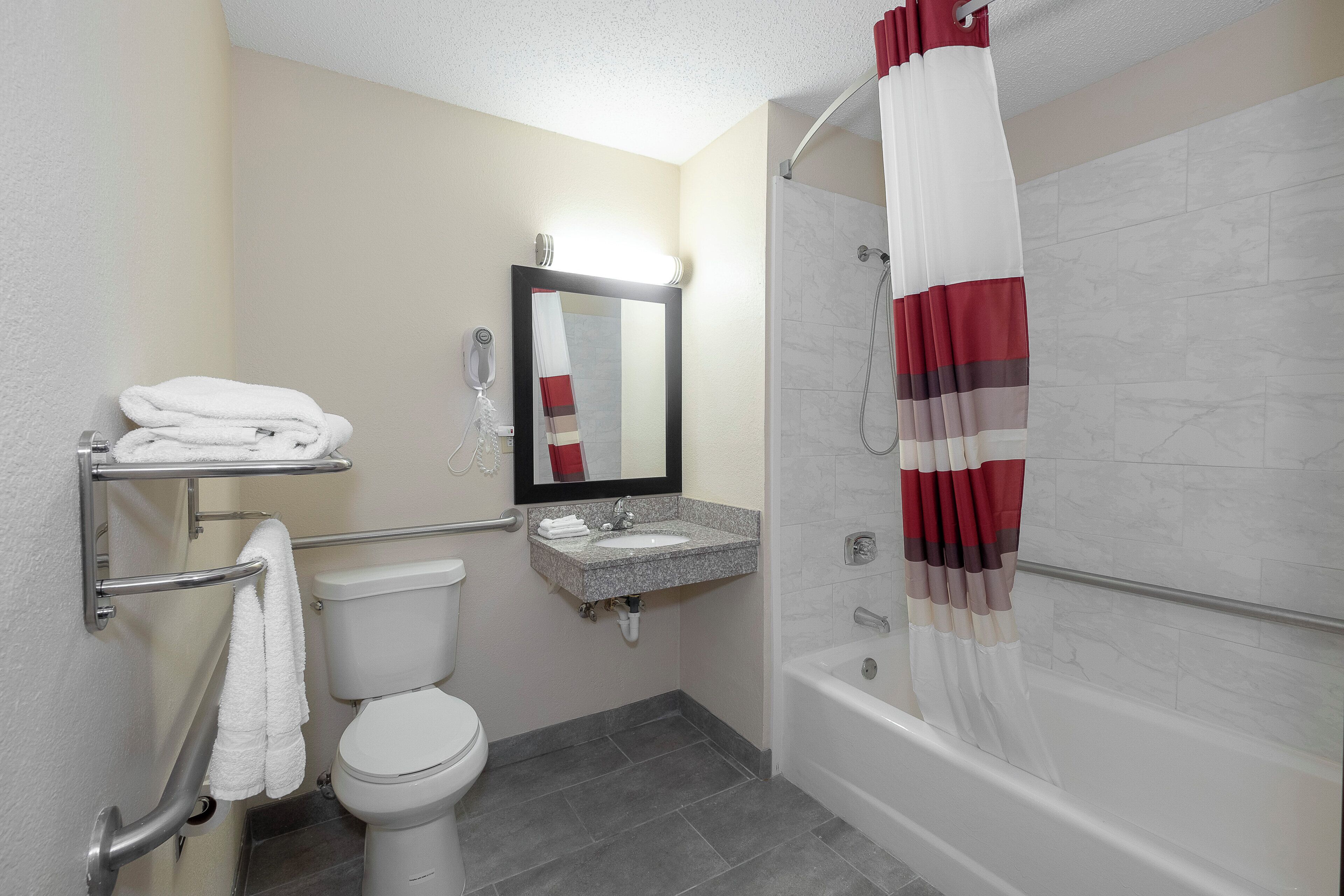 A bathroom with a toilet, sink, and shower.