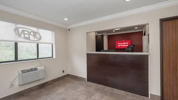 A hotel reception area with a large window, a reception desk, and a sign indicating free Wi-Fi availability.